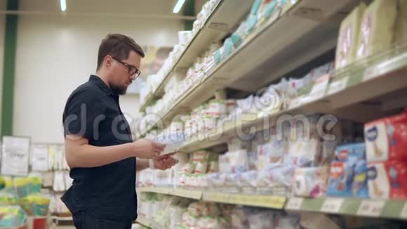 成年男子正从超市的货架上拿一包湿巾视频的预览图