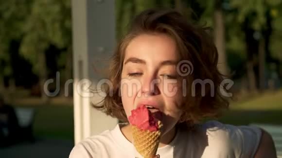 年轻的金发女人在夏天公园享受冰淇淋视频的预览图