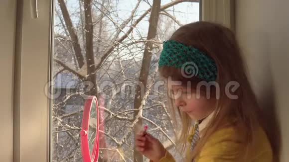 小可爱的女孩把化妆品放在窗台上视频的预览图