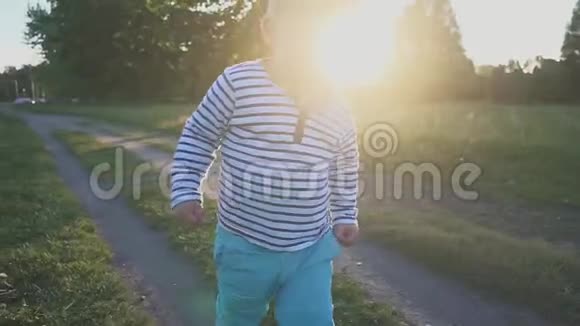 快乐的孩子跑到草地上的镜头前微笑着小男孩在草地上迈出第一步视频的预览图