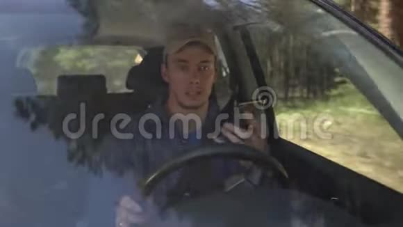 夏天年轻人围着车子在森林边开车打着电话视频的预览图