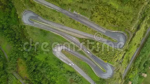 在蛇形公路上行驶的汽车在山路上的无人机视频的预览图