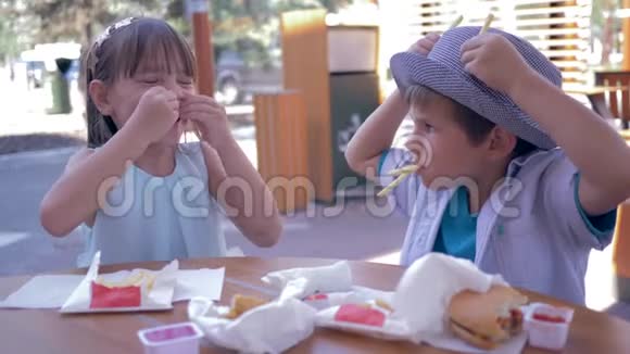 有食物的游戏快乐的孩子们朋友在街咖啡厅玩炸薯条做有趣的面孔视频的预览图