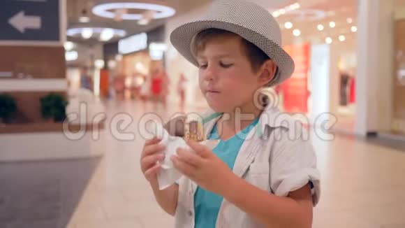 儿童食品可爱的快乐的孩子在购物中心吃巧克力甜甜圈视频的预览图
