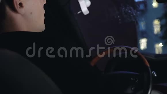 沮丧的商人坐在司机的汽车座位上在雨夜特写视频的预览图