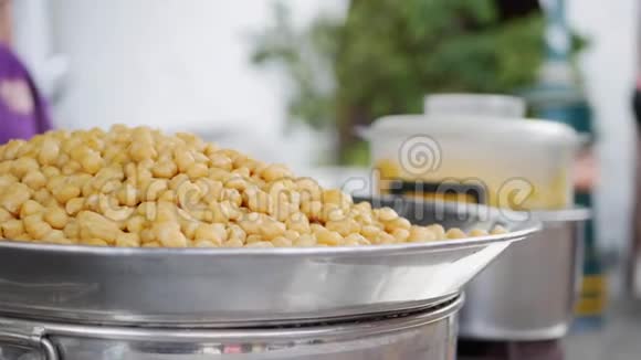很多热气腾腾的鹰嘴豆在市场上出售街头美食4k视频的预览图