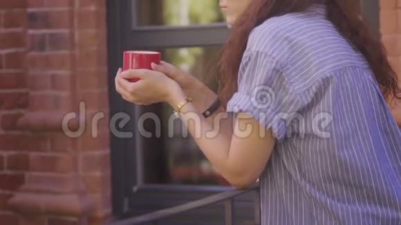 美丽的女人在外面喝咖啡一个女孩正在外面喝茶视频的预览图