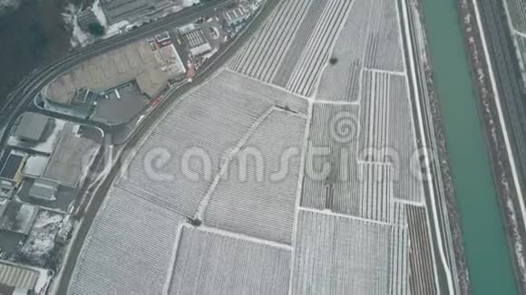 意大利北部雪覆盖的田野道路和山脉的空中景色视频的预览图