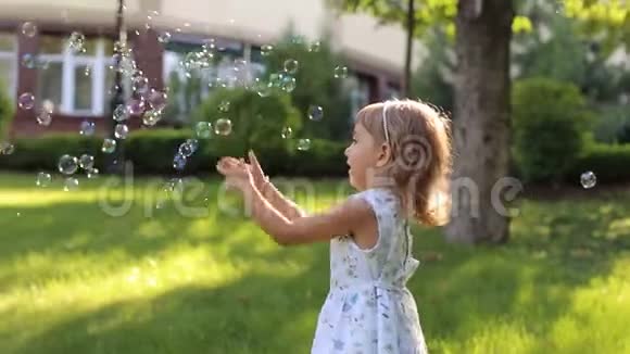 一个小可爱的女孩穿着一件夏日轻装在公园里玩肥皂泡视频的预览图
