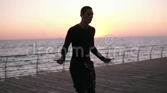 肌肉发达的年轻人在海边用跳绳锻炼的肖像从事拳击运动的年轻人视频的预览图