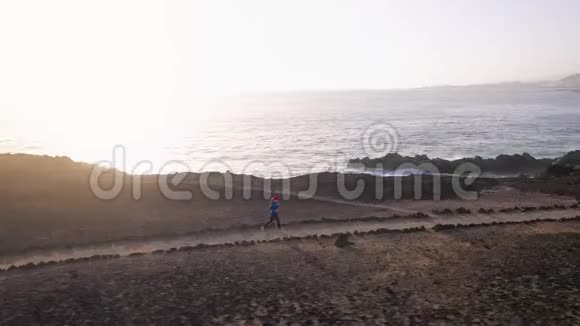 日出时女性的鸟瞰沿着海滨自然保护区健康的生活方式视频的预览图