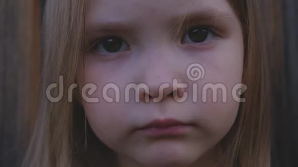 一个美丽的小女孩在户外摆姿势的特写肖像视频的预览图
