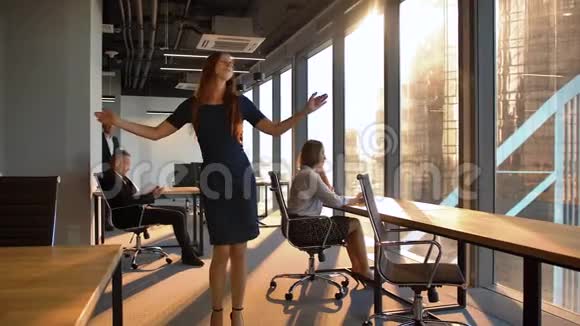 漂亮的商务女性在现代办公室里跳舞视频的预览图
