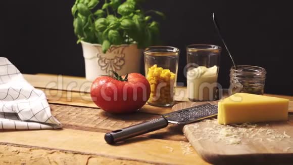 在木制餐桌上用新鲜的罗勒和多汁的番茄切碎奶酪视频的预览图