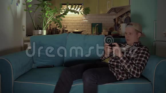 快乐的人躺在沙发上用手机玩游戏4K视频的预览图