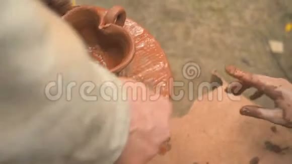 旋转陶工的车轮和粘土器皿从上面一个孩子用一个陶土杯在一个视频的预览图
