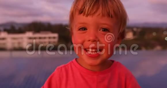 日落时看摄像机的小男孩视频的预览图