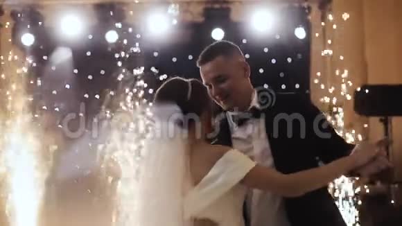 年轻美丽的新娘和新郎在被纸屑笼罩的婚礼晚会上跳舞感觉快乐视频的预览图
