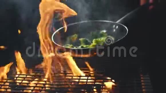 在平底锅中煮薯条会飞的蔬菜在火和煤上做饭慢动作视频的预览图