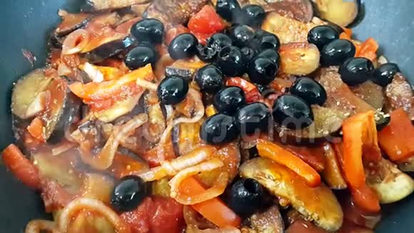 炒菜洋葱胡萝卜辣椒用黑色橄榄装饰蔬菜炖锅里炖菜的过程视频的预览图
