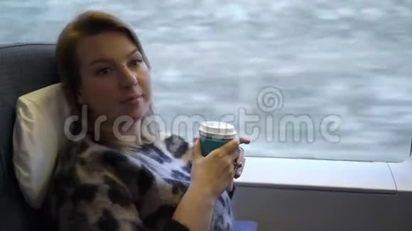 坐火车的年轻女子喝茶或咖啡视频的预览图