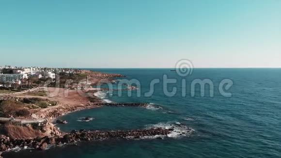 鸟瞰塞浦路斯岩石海岸与酒店和海洋半岛科利岛岩石海滩和风暴海浪的无人机拍摄视频的预览图