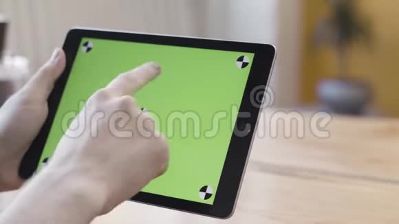 用绿色屏幕关闭手握数字平板电脑滚动滑动和敲击他的设备视频的预览图