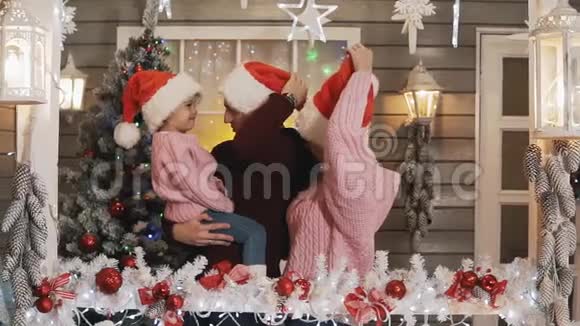 圣诞门廊上戴套头衫的幸福家庭新年树视频的预览图
