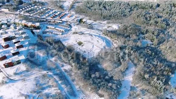雪天的乡村冬天的乡村和道路的鸟瞰动作松树的鸟瞰图视频的预览图