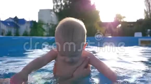 可爱的小男孩在游泳池妈妈教孩子游泳在夏季周末特写视频的预览图
