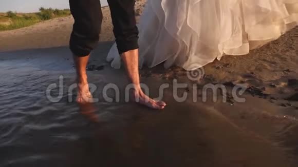 男朋友赤脚走在水上穿着白裙子的女孩走在沙滩上恋爱中的情侣散步视频的预览图