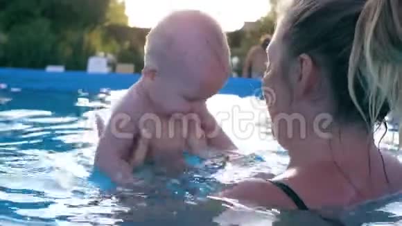 健康的家庭妈妈和孩子在游泳池里玩得开心小男孩在夏天炎热的日子里做飞溅视频的预览图