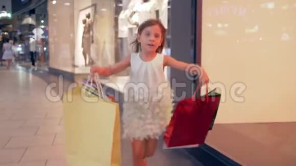 快乐的购物女孩带着纸袋匆忙在精品店打折视频的预览图