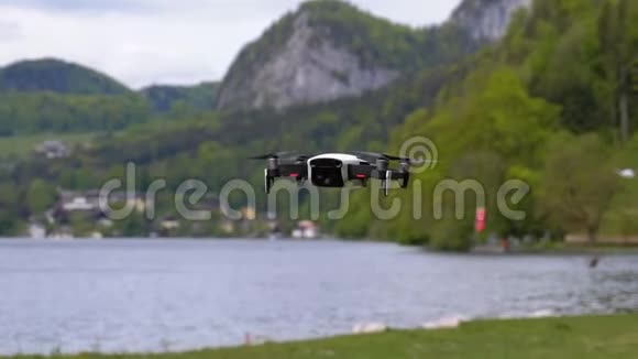 在湖和山的背景下悬挂在空中的旋转螺旋桨视频的预览图