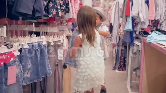 购物节假日小朋友在打折时在商店里挑选新的时尚服装视频的预览图