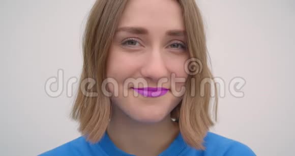 年轻的短头发女性的特写照片她涂着紫色口红微笑着看着镜头背景视频的预览图