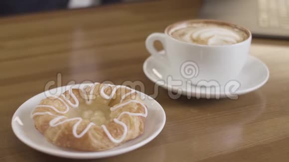 杯热咖啡和甜面包木桌上有釉库存录像提供一份自制的完美早餐视频的预览图
