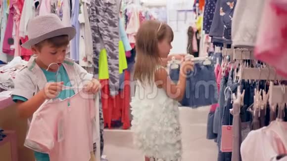 孩子们在购物小买家在昂贵的精品店里挑选新的时尚服装视频的预览图