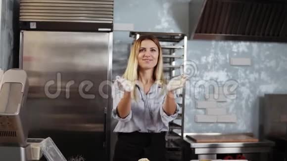 年轻的女糖果师玩味地用面粉拍手揉搓面团烹饪厨房糕点的概念视频的预览图