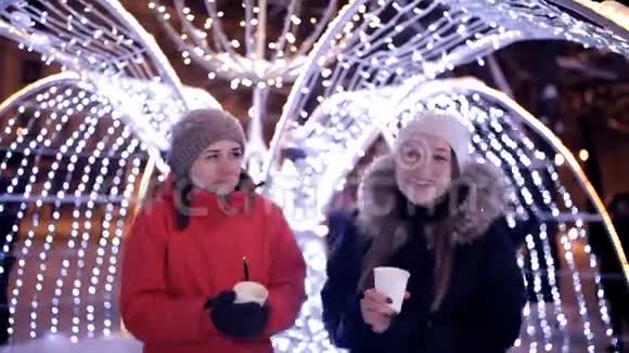 年轻女孩在冬天在市中心喝咖啡靠近冬天的装饰品圣诞节新年视频的预览图