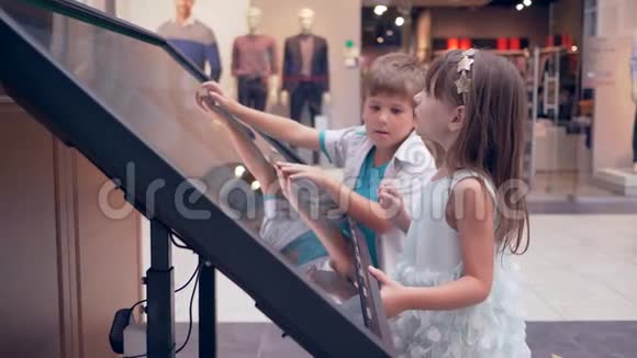 商场的现代技术小孩子朋友用交互式触摸屏显示搜索信息视频的预览图