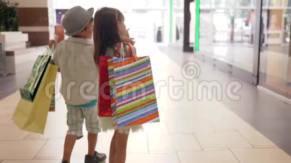 购物中心买了很多纸袋的顾客买了昂贵的东西后他们手牵着手走着视频的预览图