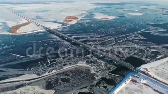 宽的冰冻河流和桥梁鸟瞰视频的预览图