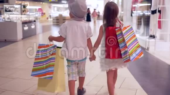 购物日时尚的小女孩和朋友在购物后一起在商场散步视频的预览图