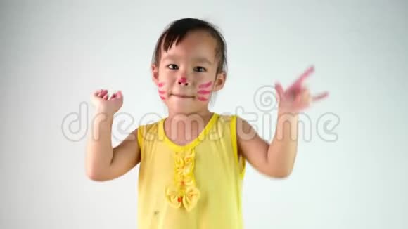 可爱的亚洲小女孩拿着画笔在白色背景上孤立地作画的肖像视频的预览图