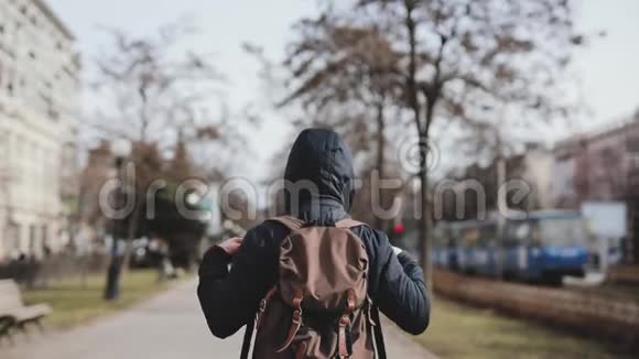 男子游客沿着城市小巷散步的后景视频的预览图