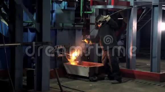 在金属熔化炉工作的工人穿着防护服视频的预览图
