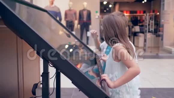 现代儿童在购物中心进行网上购物时使用交互式面板视频的预览图