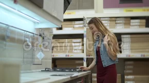 年轻女子正在一家大商店里寻找烤箱的烹饪面视频的预览图