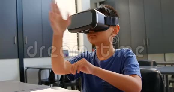 亚洲小学生坐在课桌前4k教室使用虚拟现实耳机视频的预览图
